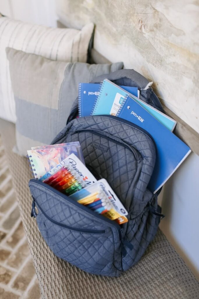 arranging kid's school items inside backpack