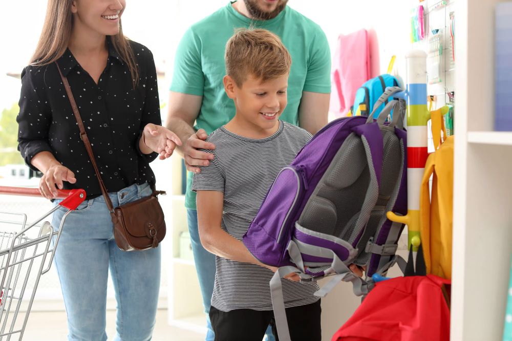 kid and his parents shopping together to avoid back to school shopping mistake