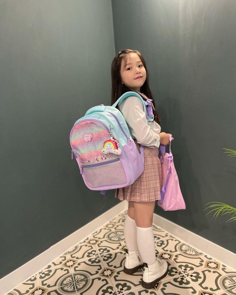 a kid dressed for school with her backpack