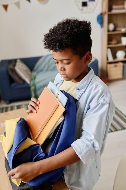 a boy packing his school backpack as school morning routine