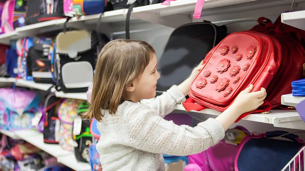 a kid choosing her own backpack