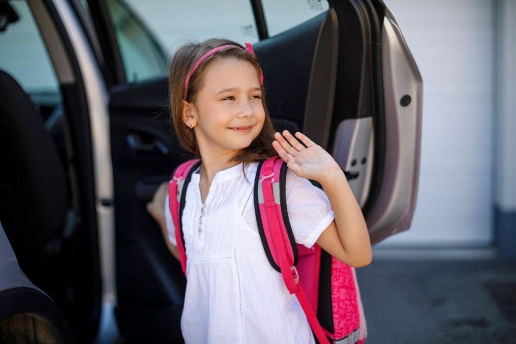 kid waving at mom as she go to school