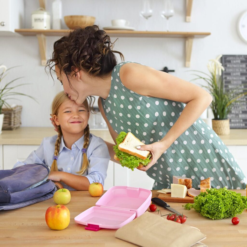 mom packing her kids lunch and she pecks her