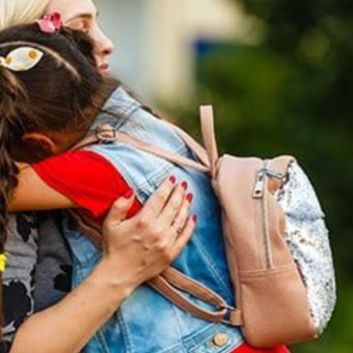 mon hugging her child after seeing her off to school