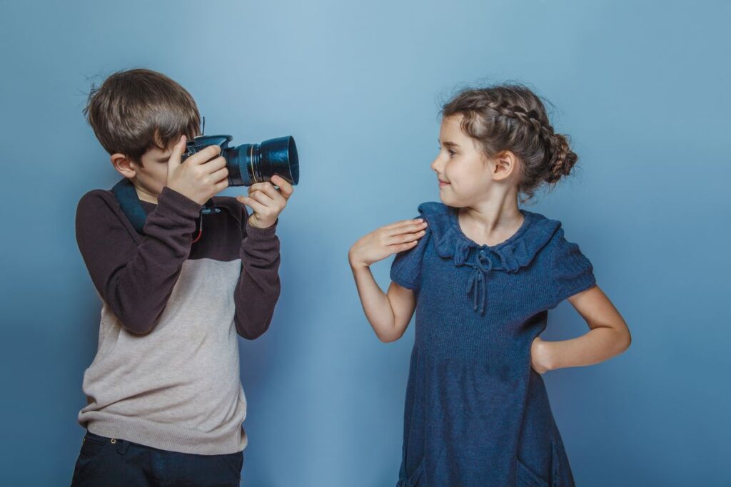kid taking his sister photo