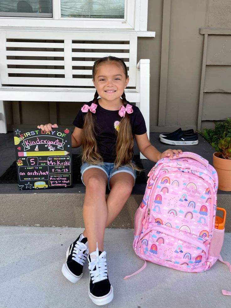 kid taking picture wile sitting down as first day of school photo ideas