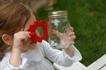 kid on a bung hunt with jar as one of the outdoor fall activities for kids