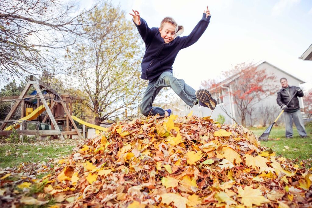 leaf pile jumping as one of the outdoor fall activities for kids