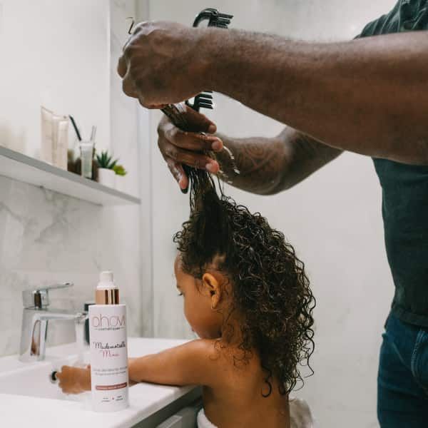 dad applying leave-in on his child's hair