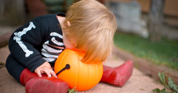 kid with plastic halloween pumpkin to make halloween less scary for kids