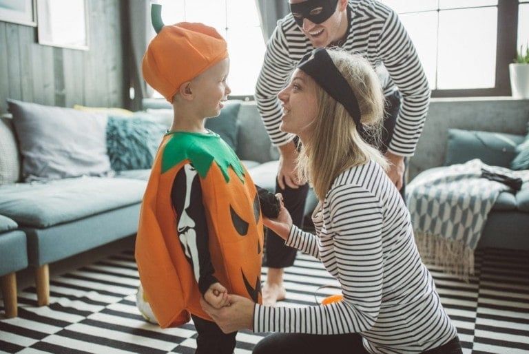 parents with their kid on halloween