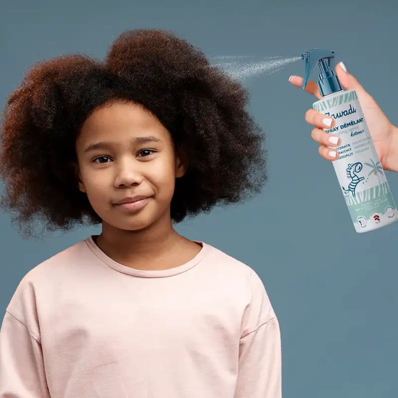 someone spraying oil on kid's hair