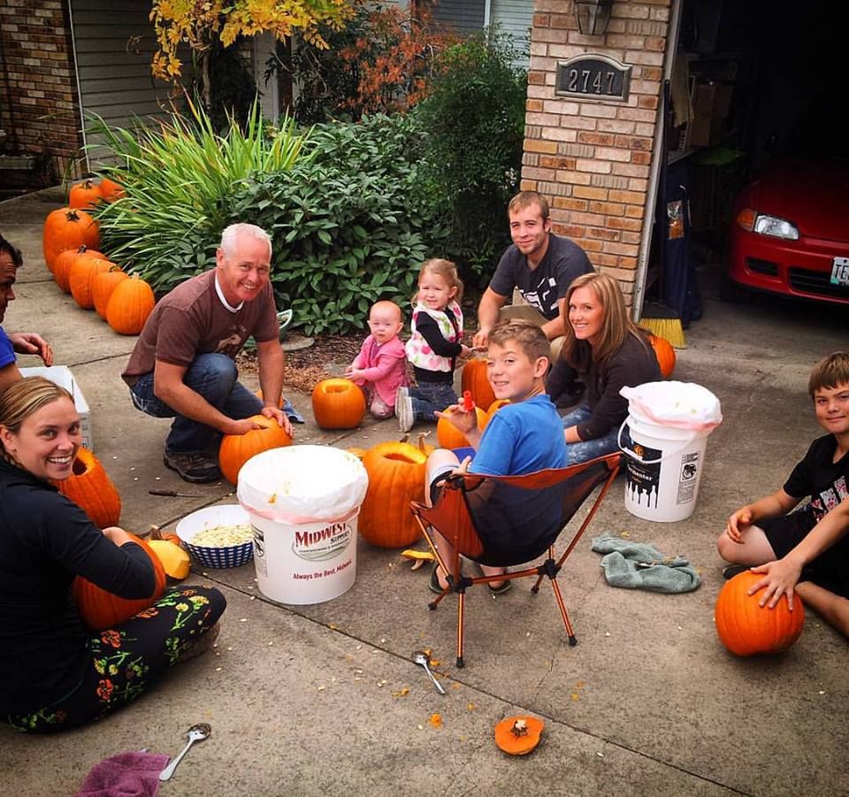 family carving pumpkins together as halloween traditions for kids