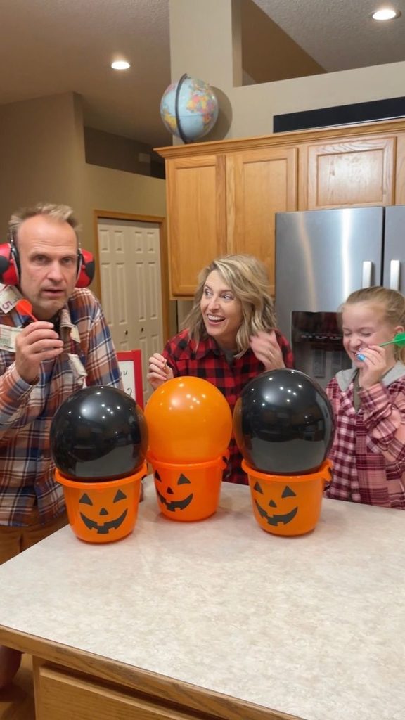 family playing halloween balloon game