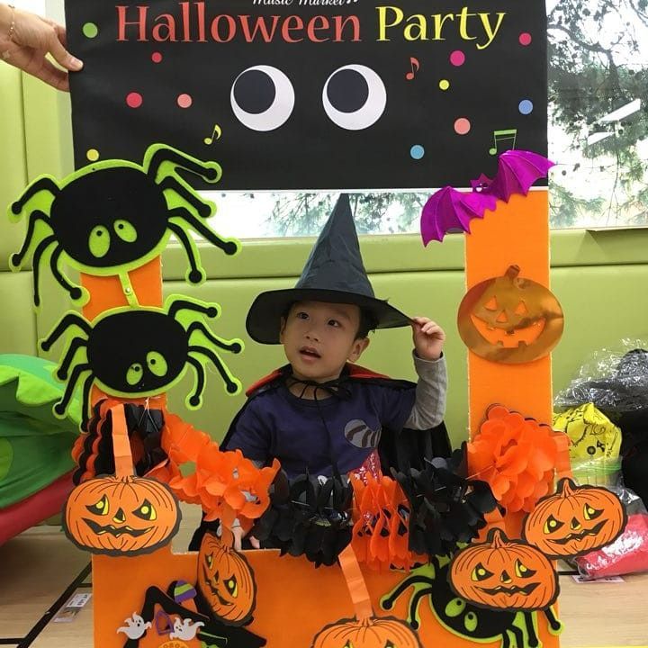 kids taking photo in halloween booth as one of halloween school party ideas 