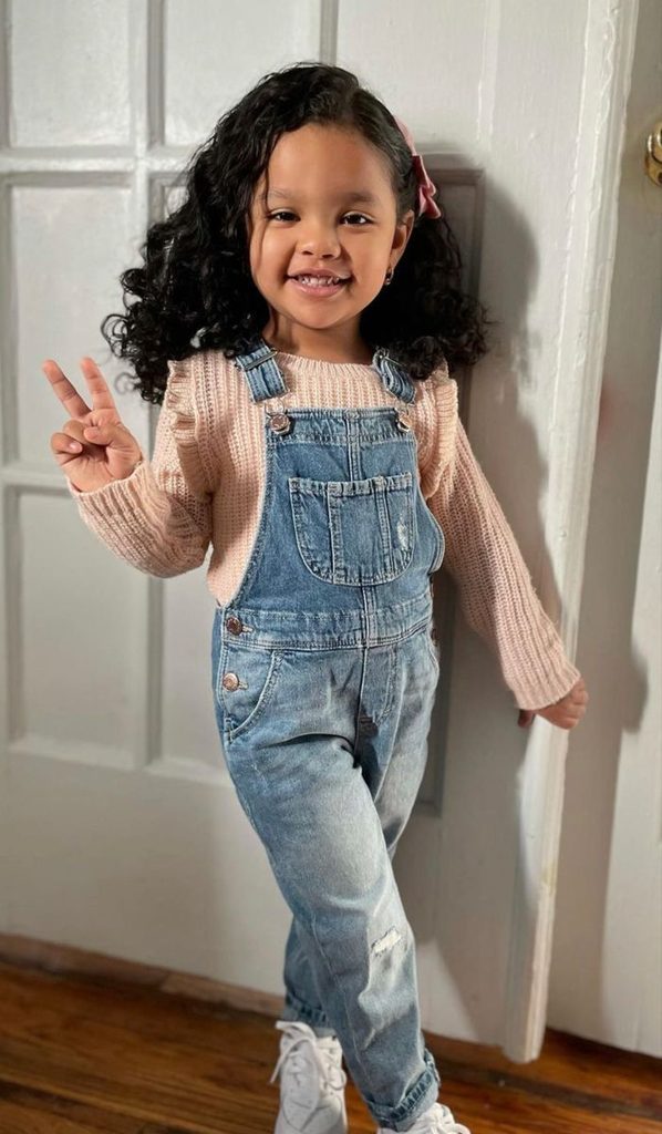 kid in jeans overalls with long sleeve top