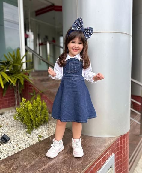 kid in Jeans with a Denim Pinafore Layered Over a Top