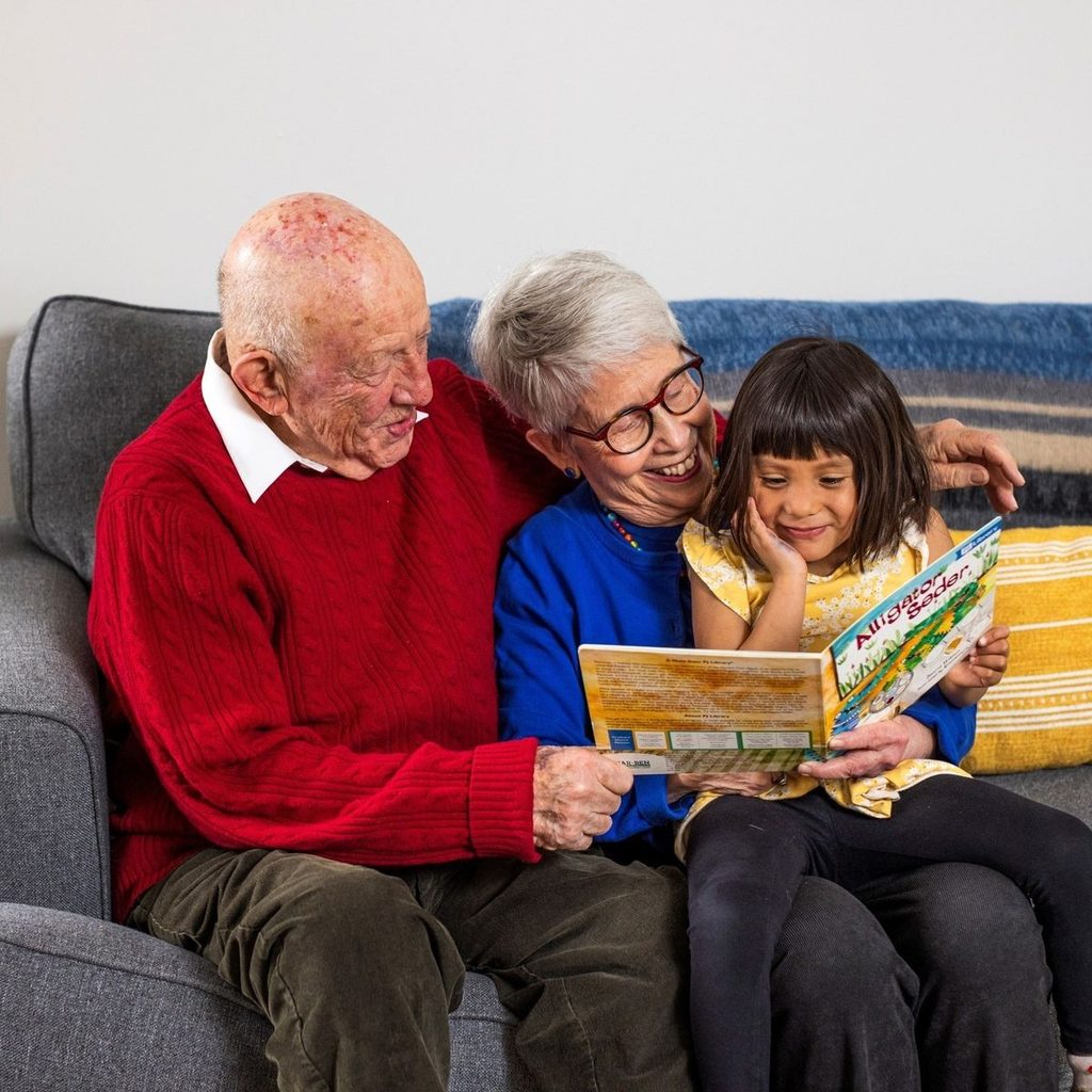 kid and grand parents reading together as halloween traditions for kids