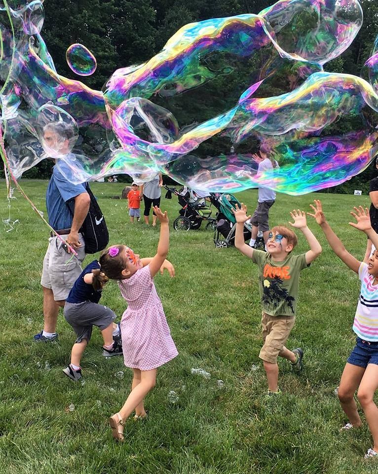 kids playing with giant bubble as backyard activities for kids