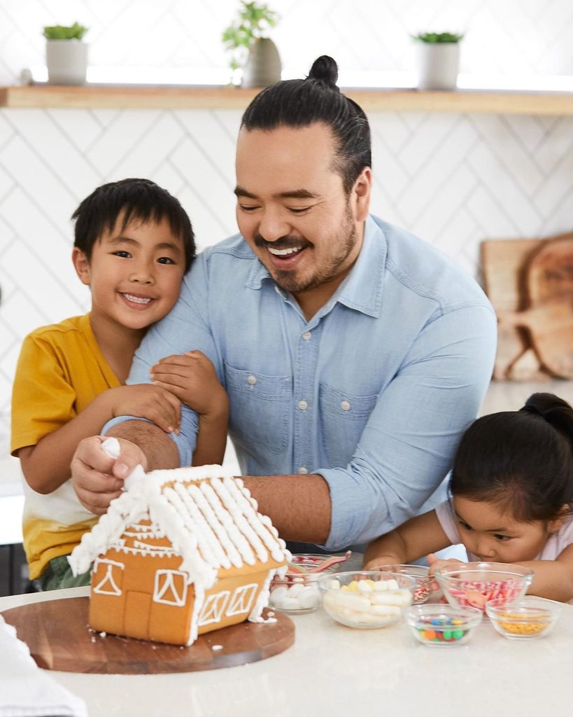 Dad and kids building a gingerbread house as Christmas activities that create magical family memories