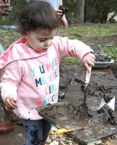 a kid building a mud kitchen