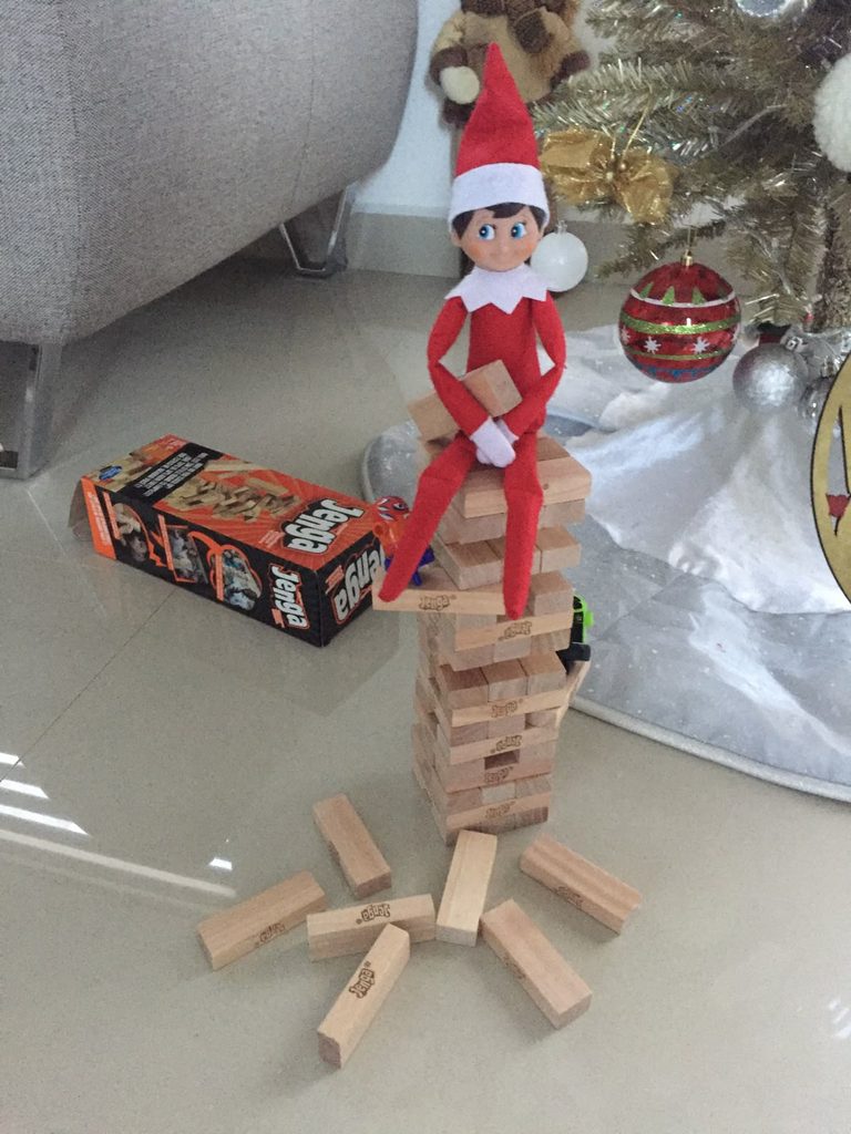 elf builds a block tower and sat on it