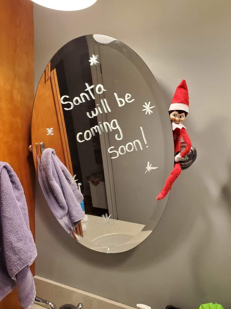 elf writes a message on the mirror as one of creative Elf on the Shelf ideas