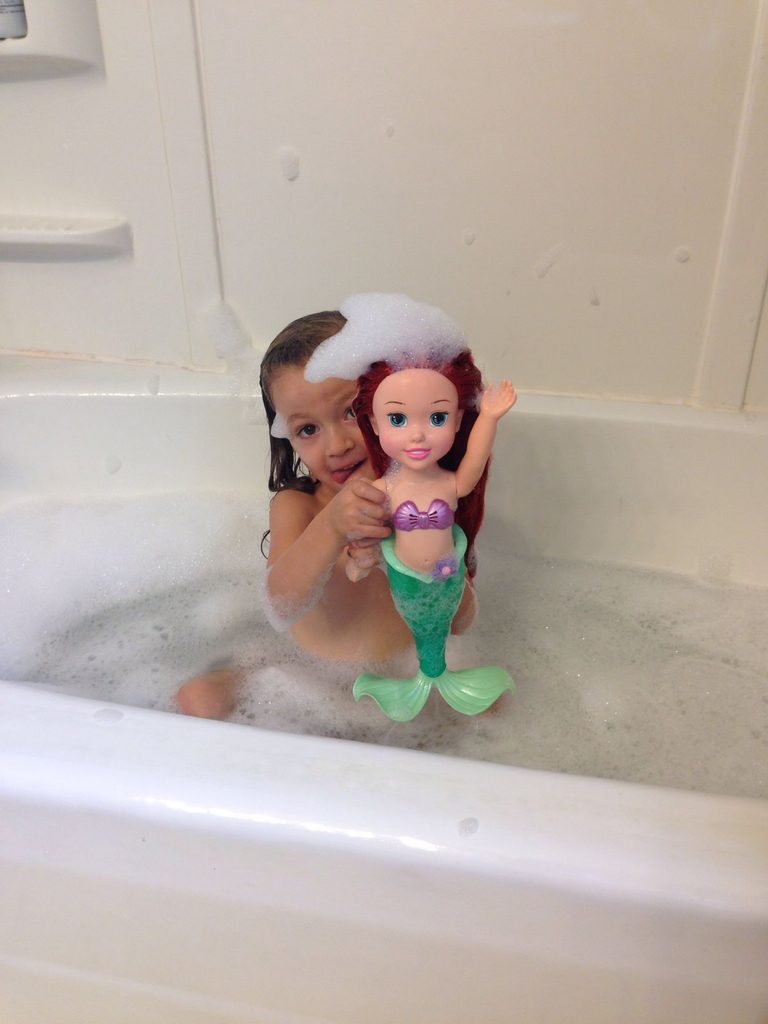 a kid with her puppet inside bathing tube