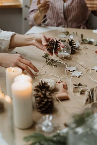 family making pinecone ornament