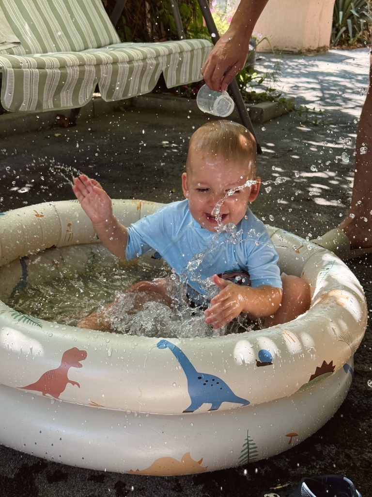 a kid in a paddling pool as water play activities for toddlers