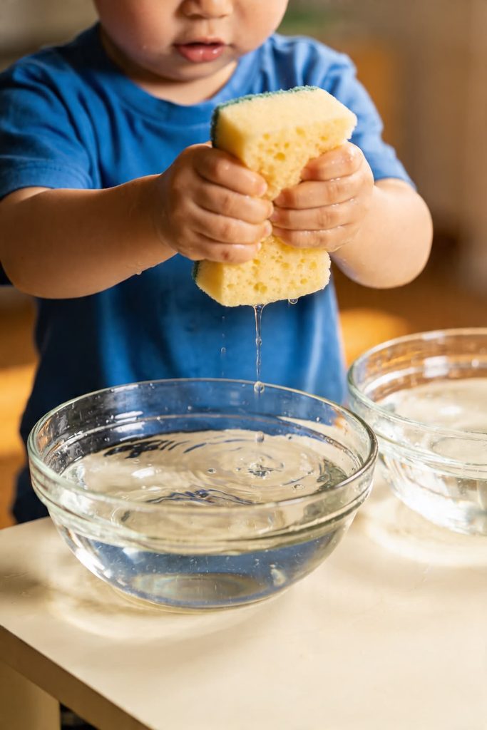 toddler squeezing a soaked sponge