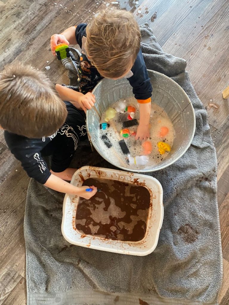 toddler washing the toy animals as water play activities for toddlers