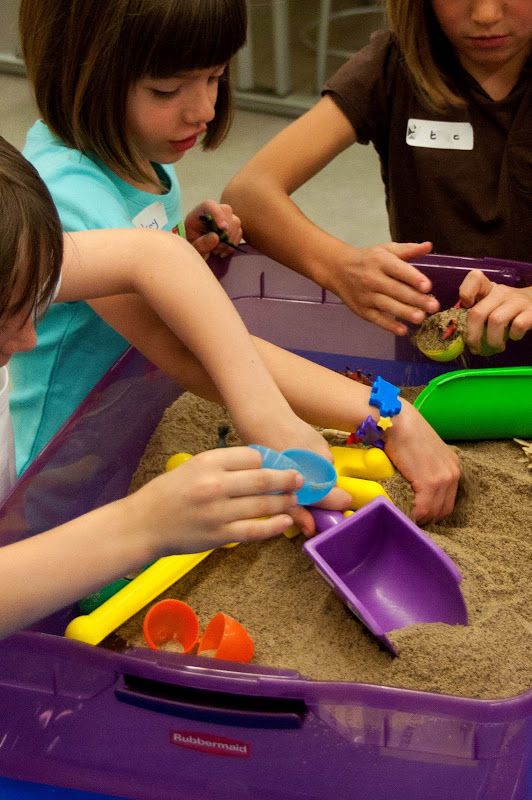 kids looking for dinosaur inside sand